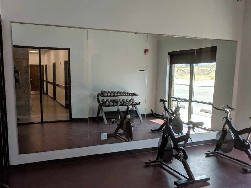 A gym room with exercise bikes and mirrors, perfect for working out and checking form.


