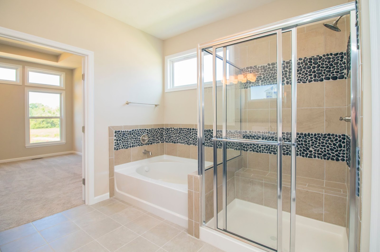 A bathroom with a shower, tub, and toilet. Glass shower doors, shower curtains, and shower doors are present.