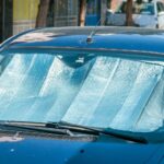 A blue car with a blue windshield, highlighting the importance of windshield replacement in summer heat conditions.