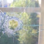 A broken window with a bullet hole, showing window damage in the home.