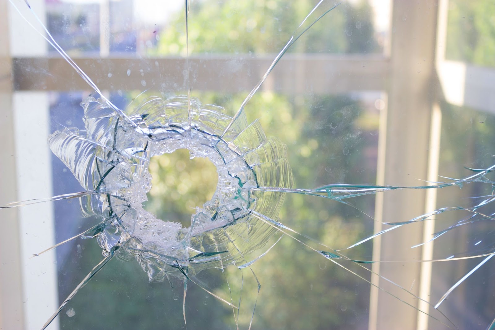 A broken window with a bullet hole, showing window damage in the home.