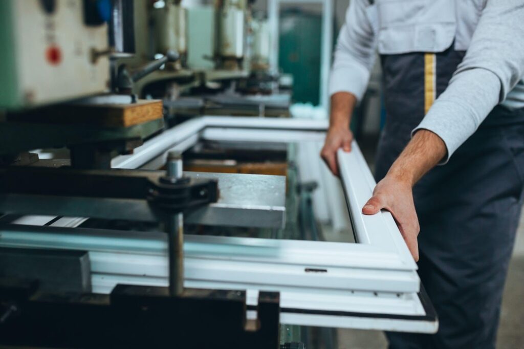 Man operating a machine to create a window frame